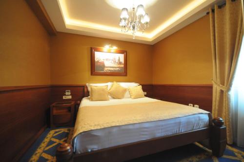 a bedroom with a bed and a chandelier at Luxury Sea Residence by Kristina in Tivat