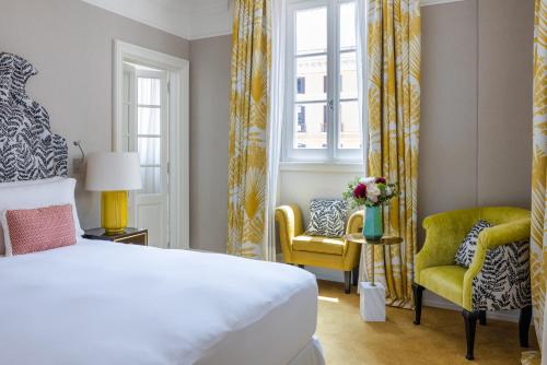 a bedroom with a bed and two chairs and a window at Maalot Roma - Small Luxury Hotels of the World in Rome