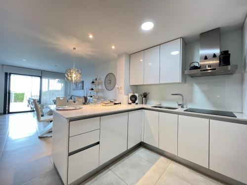 a kitchen with white cabinets and a dining room at Ocean View Apartment in Arenales del Sol
