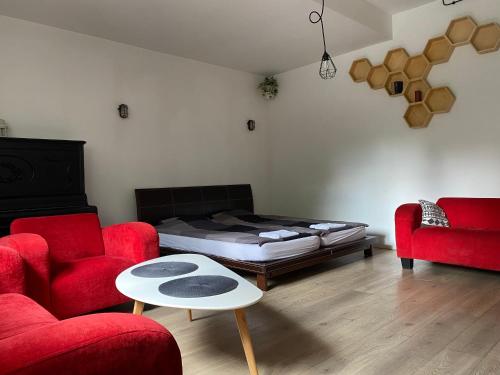 sala de estar con 1 cama y 2 sillas rojas en SPOKO Hostel, en Gdansk