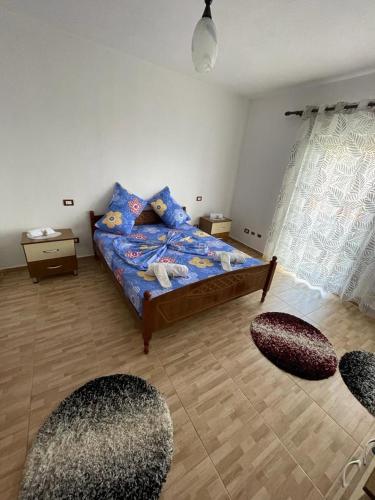 a bedroom with a bed and two ottomans at Vila Du Lac Blue in Pogradec