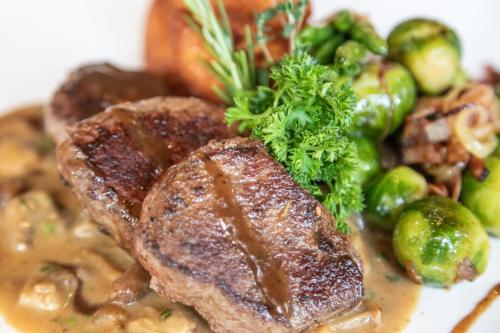 a plate of food with meat and vegetables on it at Gasthof Leitner - Der Wirt an der Klamm in Donnersbach