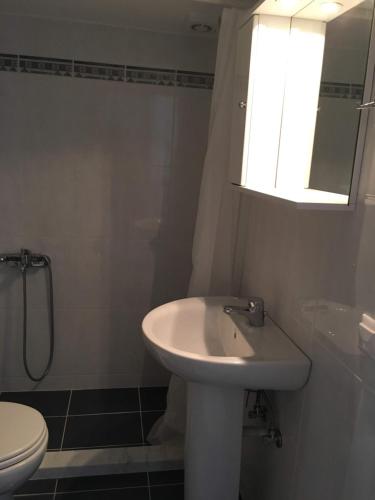 ein Badezimmer mit Waschbecken und Toilette und einem Fenster in der Unterkunft Spacious Apartment Skala Fourkas in Skála Foúrkas