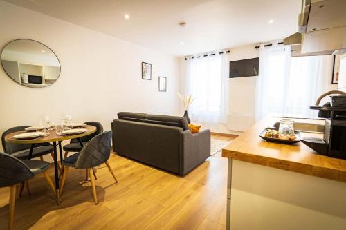 un salon avec un canapé et une table dans l'établissement L'Albatros 007 - Hypercentre * Cosy * Wifi, à Saint-Quentin