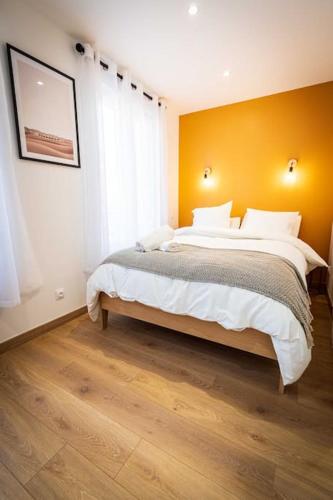 - une chambre avec un grand lit et un mur jaune dans l'établissement L'Albatros 007 - Hypercentre * Cosy * Wifi, à Saint-Quentin