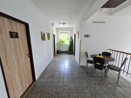 a hallway with a table and chairs and a door at NIKA beds in Pardubice