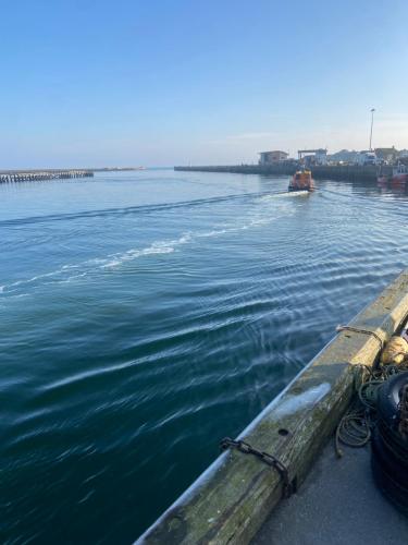 a boat in the water next to a pier at Stunning quirky home in Amble in Amble