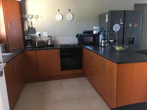 a kitchen with wooden cabinets and a black counter top at Unit 30 The Beacon in East London