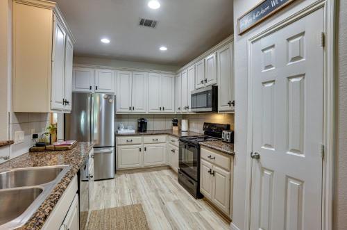a kitchen with white cabinets and a stainless steel refrigerator at Community Pool Access Montgomery Retreat! in Montgomery