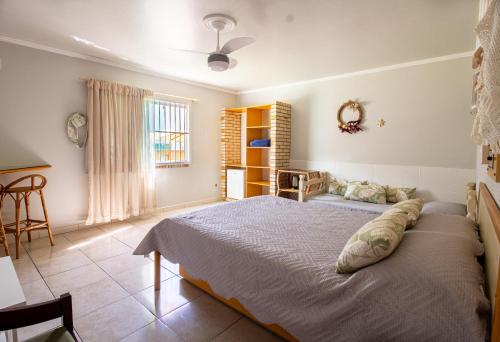 1 dormitorio con 1 cama grande y 1 mesa en Conves suites en Penha