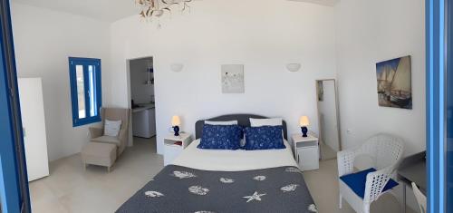 a bedroom with a bed and a desk and a chair at Luxury studio on the beach in Ios Chora