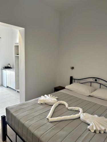 1 cama con 2 toallas en un dormitorio en Santorini Style Rooms, en Vóthon