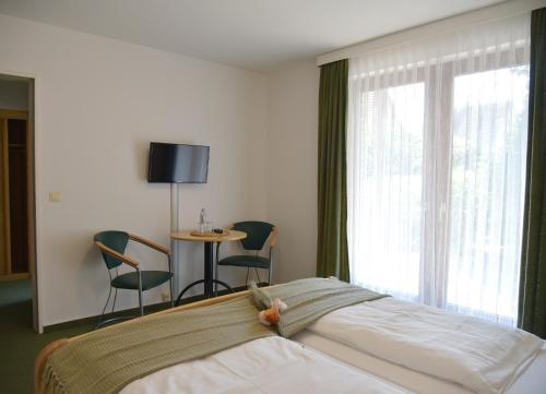 a bedroom with a bed and a table and chairs at Pension Haus Bambi in Mölln