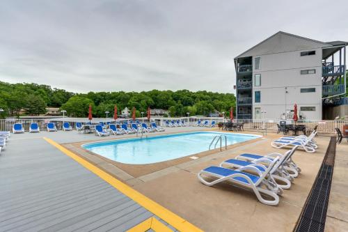 a swimming pool with lounge chairs and a building at Condo with Community Pool and Boat Ramp in Osage Beach in Osage Beach