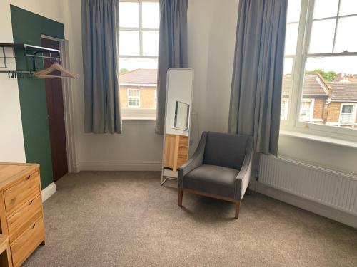 a room with a chair and a television and windows at The Fox & Hounds in Forest Hill