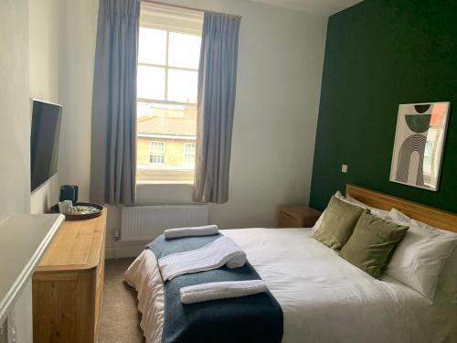 1 dormitorio con cama, escritorio y ventana en The Fox & Hounds en Forest Hill