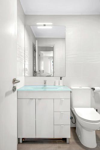 a white bathroom with a sink and a toilet at Bright Algés Apartment by Lisbeyond in Algés