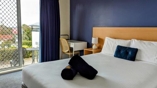 um quarto de hotel com uma cama e uma varanda em Armidale Inn em Armidale