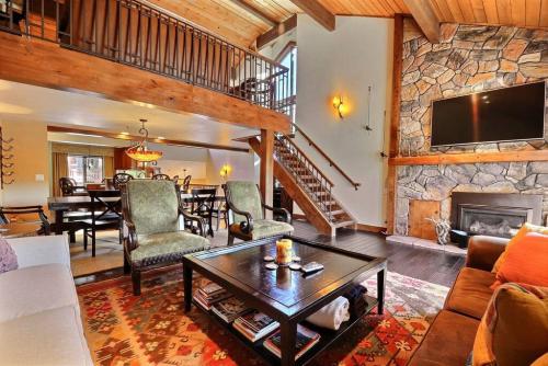 - un salon avec une cheminée en pierre et une table dans l'établissement RP128 Ski-IN OUT Silver Lake, à Park City