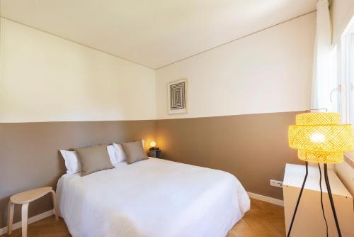 Un dormitorio con una gran cama blanca y una ventana en Olala Ribeira Apartment en Cascais