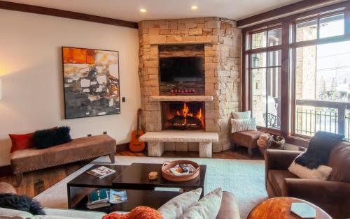 a living room with a large stone fireplace at AR414B Aspen Dreams Ski-IN OUT in Park City