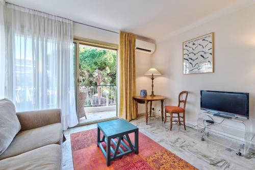 un salon avec un canapé et une télévision dans l'établissement Appartement le San Francisco bright and calm 3 bedroom flat, à Cannes
