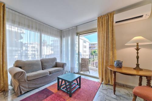un salon avec un canapé et une table dans l'établissement Appartement le San Francisco bright and calm 3 bedroom flat, à Cannes