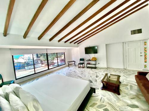 ein Schlafzimmer mit einem großen weißen Bett und einem großen Fenster in der Unterkunft San Laurent in Cali
