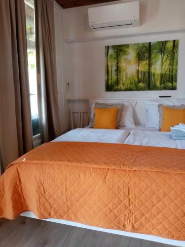 モトヴンにあるStudio apartman Bel Vedereのベッドルーム1室(オレンジ色の枕が備わるベッド2台付)