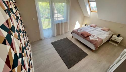 um quarto com uma cama e uma grande janela em Pacek Keco em Alsóörs