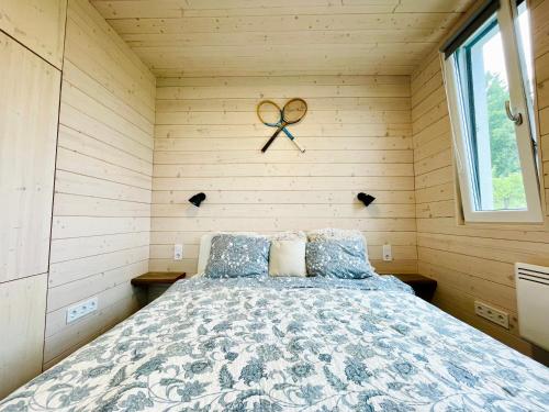 a bedroom with a bed in a wooden wall at Wine & Space Lodge at Lake Balaton in Balatonlelle