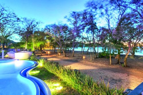 a swimming pool with lights next to a park at CC Beach Front Papagayo All Inclusive in Papagayo, Guanacaste