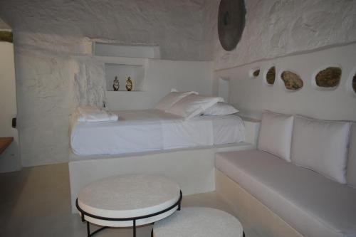 1 dormitorio con cama, mesa y taburete en CALDERA CASABLANCA, en Áno Meriá