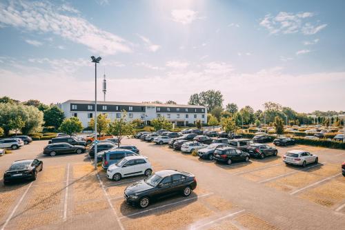 a parking lot with cars parked in front of a building at Hotel Ter Elst in Edegem