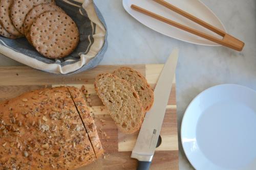 a cutting board with two slices of bread and a knife at Forskarhotellet in Lund