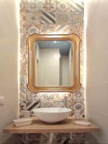 ein Badezimmer mit Waschbecken und Spiegel an der Wand in der Unterkunft PalermHost in Palermo