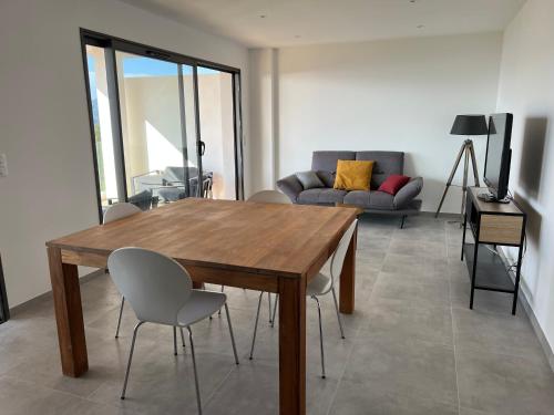 un salon avec une table et des chaises en bois dans l'établissement LOCA VACANCES, à Porticcio