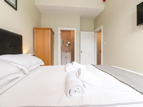 a bedroom with a large white bed with towels on it at Wansfell Loft in Ambleside