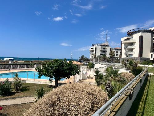 une vue depuis le balcon d'un complexe hôtelier avec piscine dans l'établissement En front de Mer, Magnifique Appartement 6 pers., au Cap d'Agde