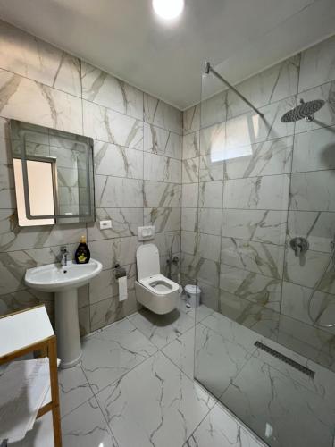 y baño con aseo, lavabo y ducha. en Restorant Hotel Xheni, en Durrës