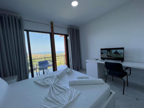 a bedroom with a bed and a desk and a window at Restorant Hotel Xheni in Durrës