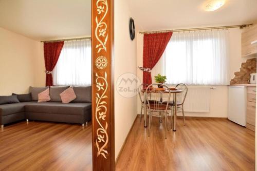 ein Wohnzimmer mit einem Sofa und einem Tisch in der Unterkunft Willa Swajnos in Zakopane