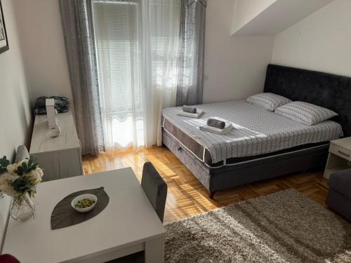 a small bedroom with a bed and a table at Zora Apartment in Plužine