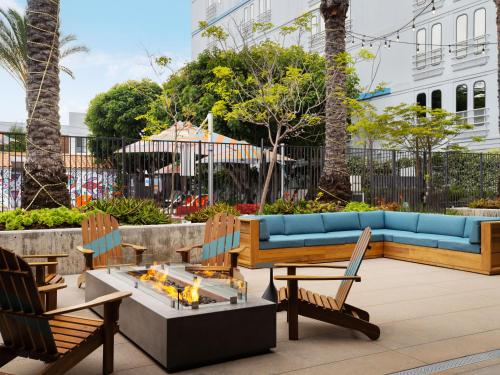 a patio with a blue couch and chairs at Aloft El Segundo - Los Angeles Airport in El Segundo