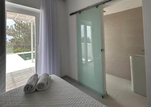 a bedroom with a bed with two towels on it at serene villas in Ierápetra