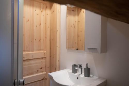 La salle de bains est pourvue d'un lavabo et d'une armoire en bois. dans l'établissement Marjeta, à Begunje na Gorenjskem