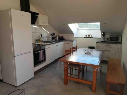 une cuisine avec une table et un réfrigérateur blanc dans l'établissement Location T4 entre Lac & Montagne, à Montgardin