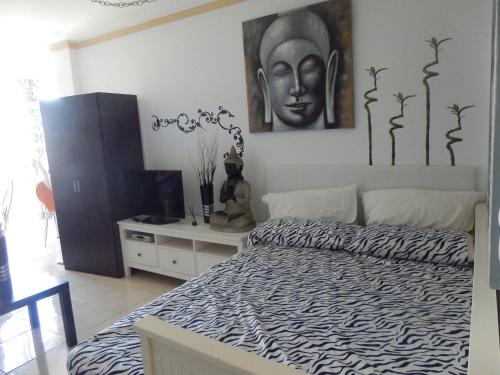 sypialnia z łóżkiem i obrazem na ścianie w obiekcie Estudio Deluxe El Faro w mieście Torrox Costa