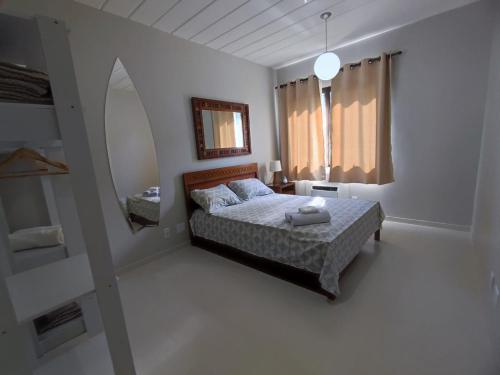 Porto Bali - Resort Mercure في انغرا دوس ريس: غرفة نوم بيضاء مع سرير ومرآة