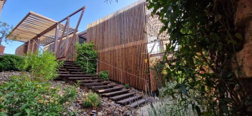 uma escada de madeira que leva a um edifício com uma cerca em Casa Cuartel Centenillo - Alojamientos Rurales en Sierra Morena em El Centenillo